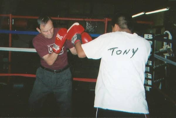 Wall murals Young professional boxer training with punching bag in